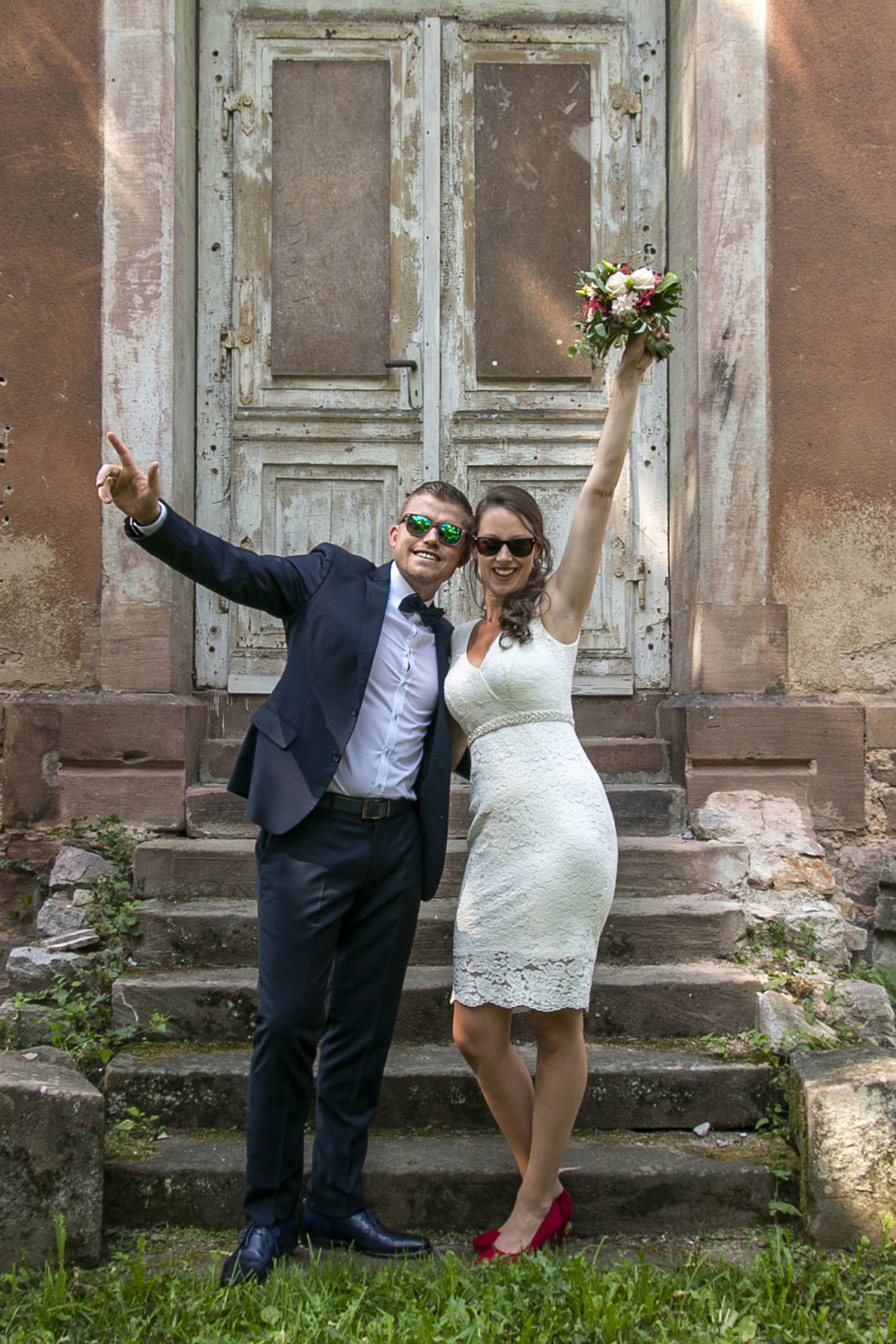 Jubelndes Brautpaar mit Sonnenbrillen