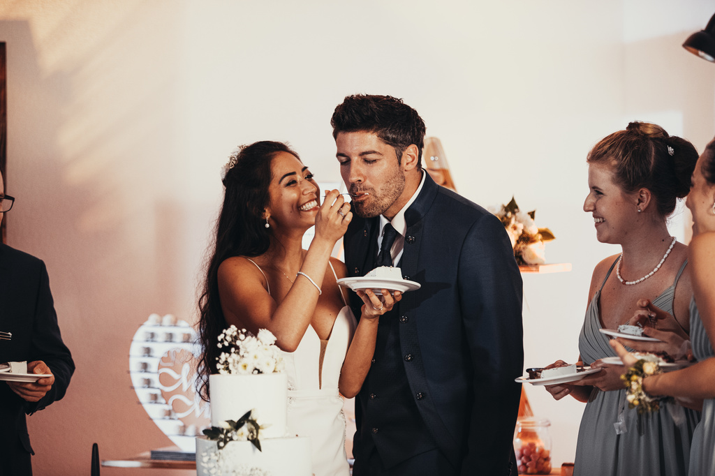 Die Braut gibt dem Ehemann ein Stück Torte.
